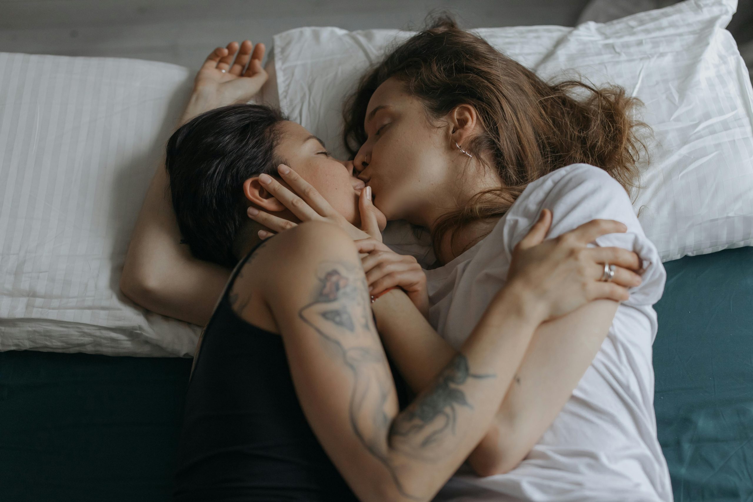 two people kissing in bed