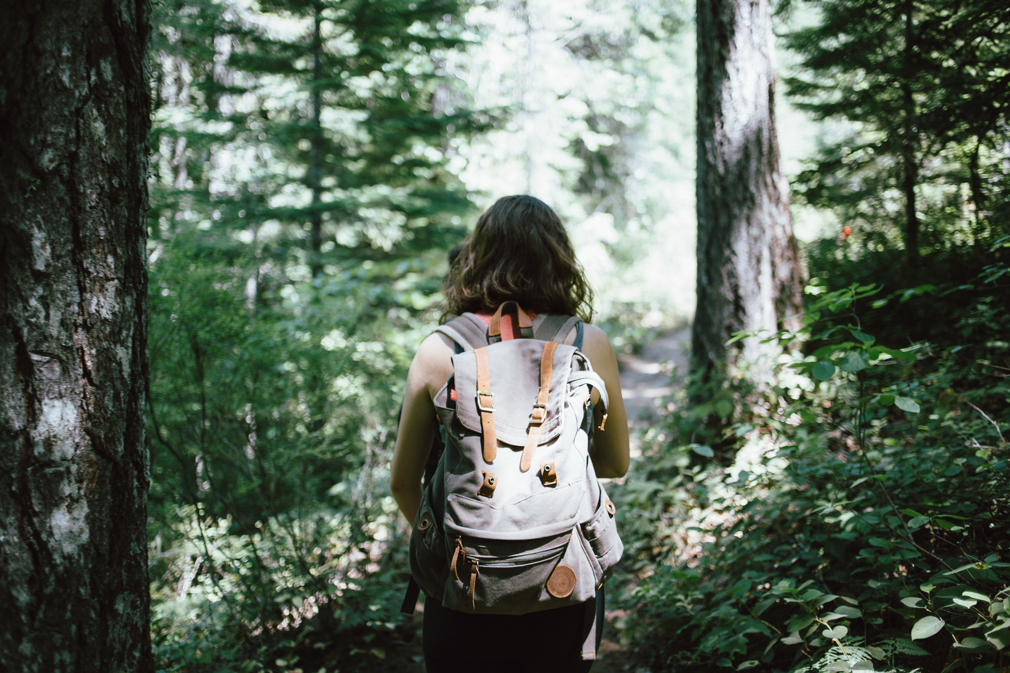 Woman wearing a backpack and walking through the woods
