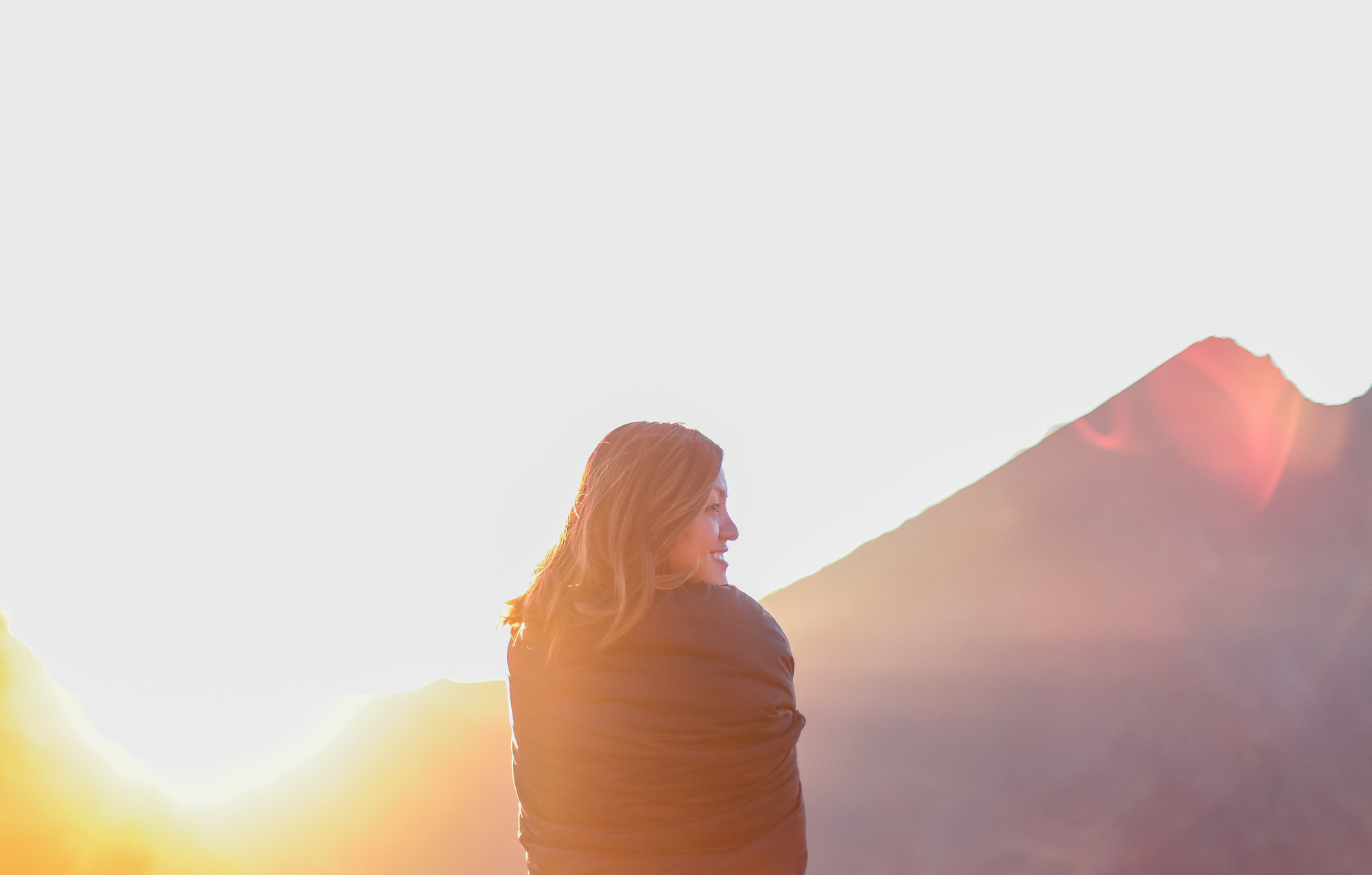 Women looking over her shoulder and smiling during sunrise