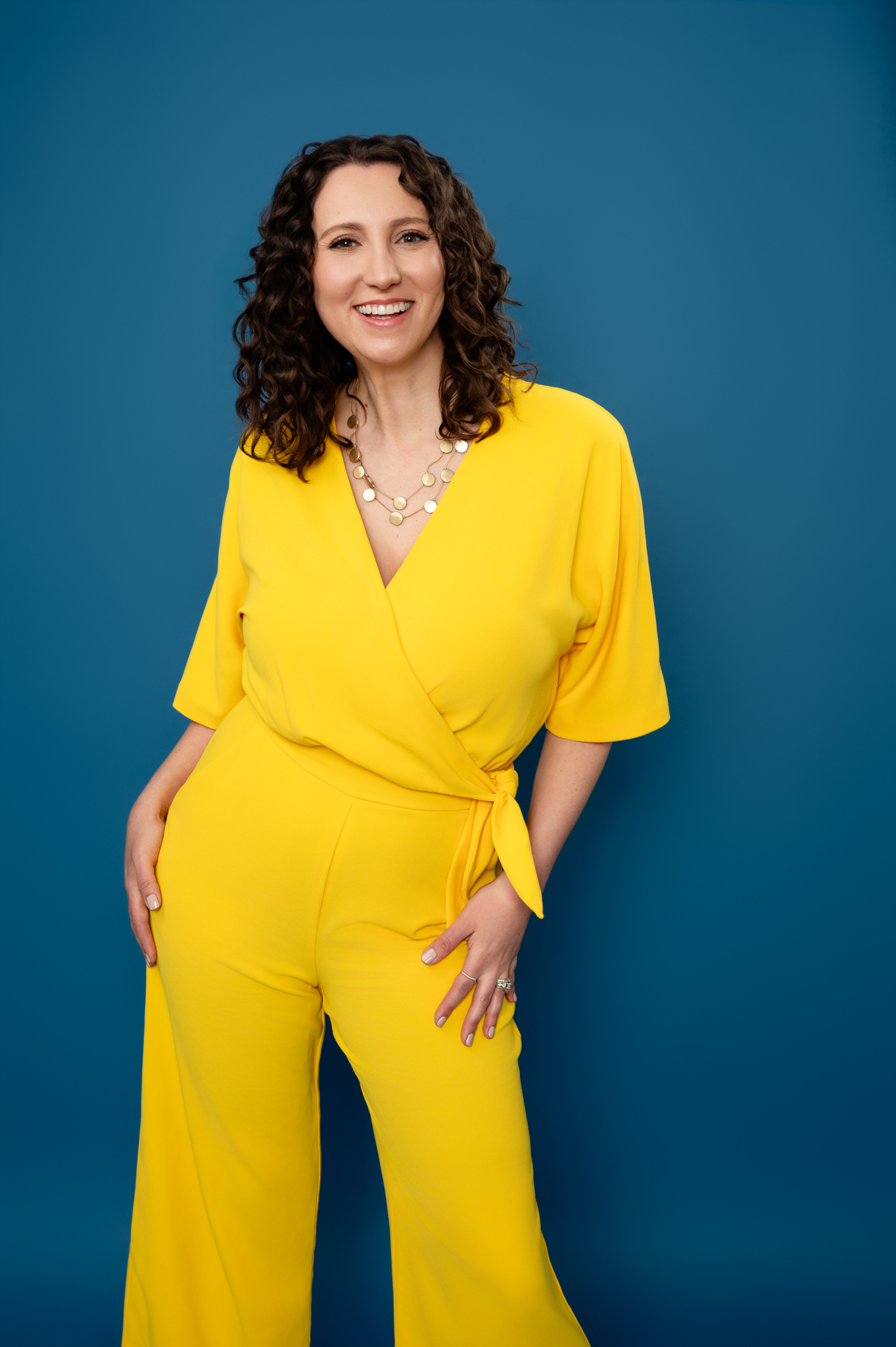 Therapist Jodi Williams standing in a yellow jumpsuit.